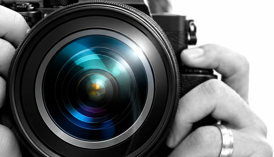Photographer holding a professional camera with the lens facing forward
